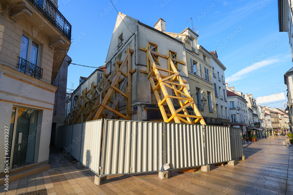 Wooden supports reinforcing an old building in the city center of Meaux in the department of Seine et Marne near Paris, France - House at risk of collapse presenting cracks on its facade