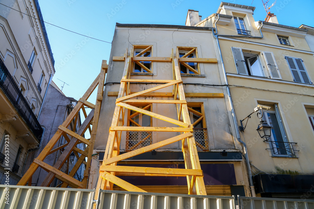 Wooden supports reinforcing an old building in the city center of Meaux in the department of Seine et Marne near Paris, France - House at risk of collapse presenting cracks on its facade Wooden supports reinforcing an old building in the city center of Meaux in the department of Seine et Marne near Paris, France - House at risk of collapse presenting cracks on its facade