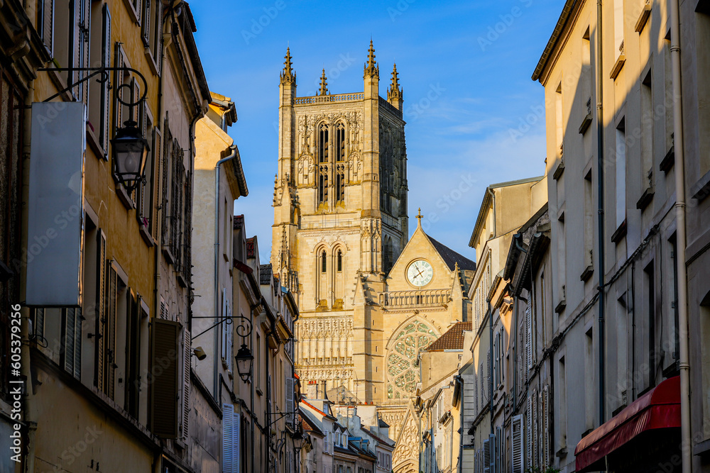 Saint Etienne Cathedral of Meaux in the sun, as seen at the end of a dark narrow shopping street in the department of Seine et Marne near Paris, France