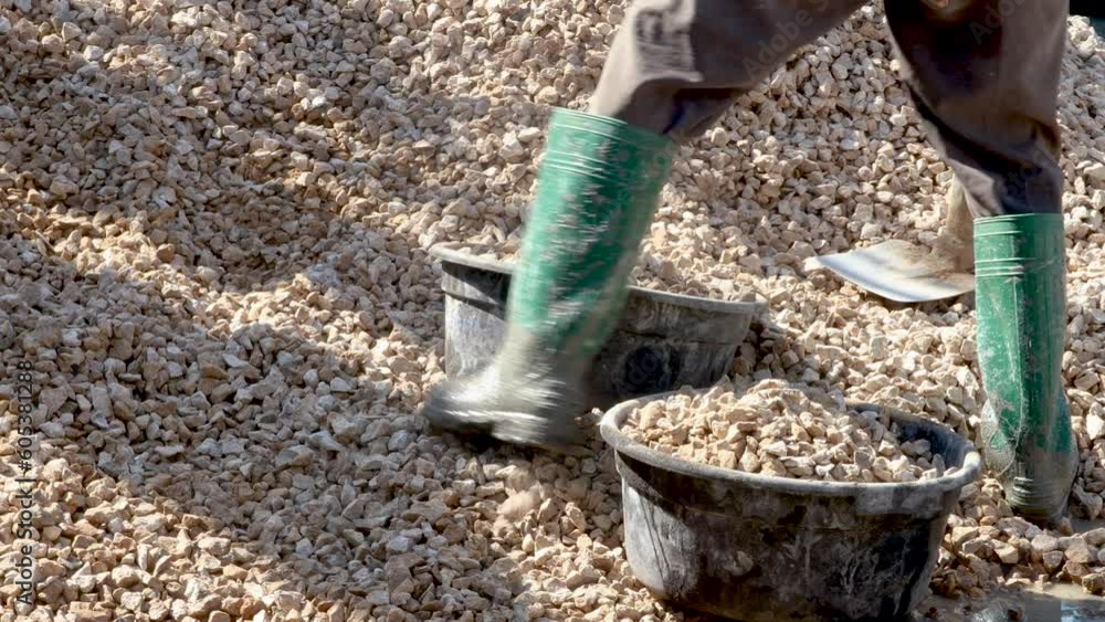 Construction worker preparing crushed stone for building house. Construction worker preparing crushed stone for building house.