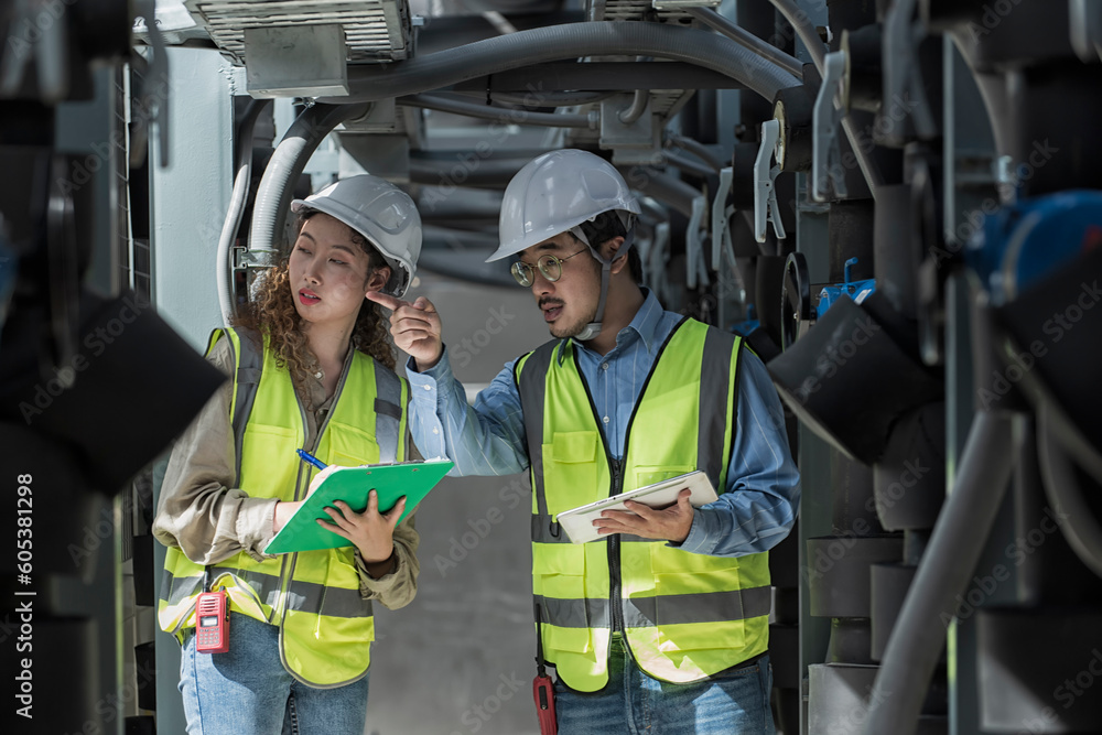 worker checking job in plant room. worker co-worker on Air condition system plant on background. engineer female and male checking on Air condition plant. Two worker working on Air condition (HVAC). worker checking job in plant room. worker co-worker on Air condition system plant on background. engineer female and male checking on Air condition plant. Two worker working on Air condition (HVAC).