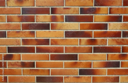 Wall with brown shades tiles in imitation of a brick wall. Background and texture.