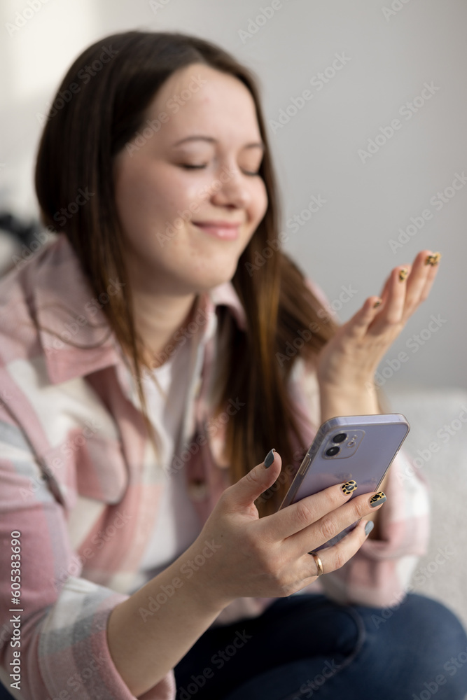 Young beautiful woman sitting at home and communicating on a smartphone with her loved one and happy Young beautiful woman sitting at home and communicating on a smartphone with her loved one and happy