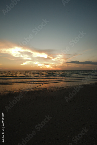 Sunset dark at Florida beach. Calm water with yellow sky from sun. Pass-a-Grille beach