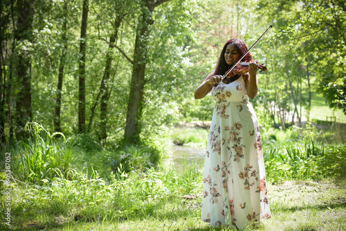 young woman playing the violin in a park in France