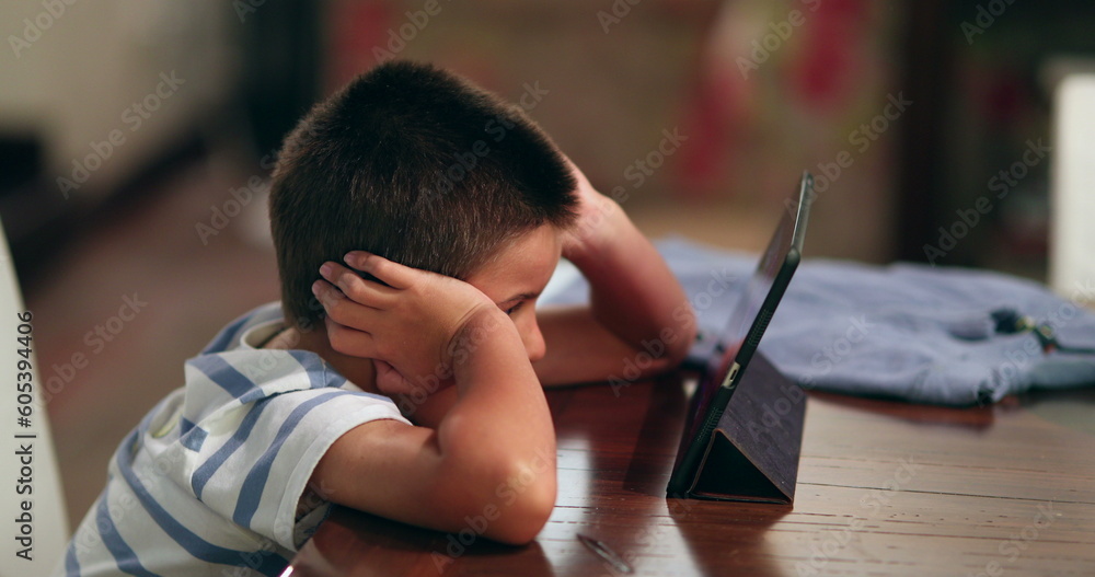 Boy watching movie on tablet. Child watches content online on tech device Boy watching movie on tablet. Child watches content online on tech device