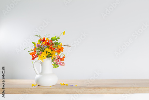 Fototapeta Naklejka Na Ścianę i Meble -  summer flowers in white jug on wooden table