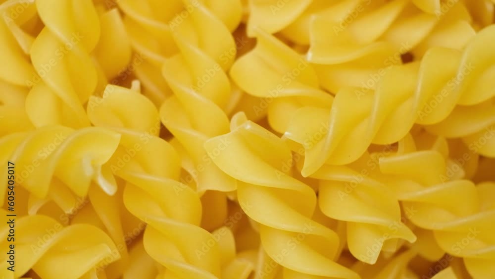 Wheat pasta fusilli in the form of spirals falling from top to bottom, slow motion Wheat pasta fusilli in the form of spirals falling from top to bottom, slow motion