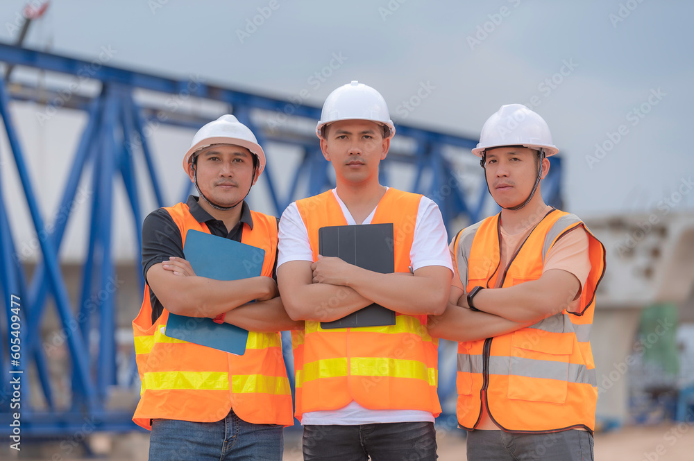 Group of asian engineers discuss about work at site of building under construction,The contractor team discusses the design of the structure,Three workers are working outside. Group of asian engineers discuss about work at site of building under construction,The contractor team discusses the design of the structure,Three workers are working outside.