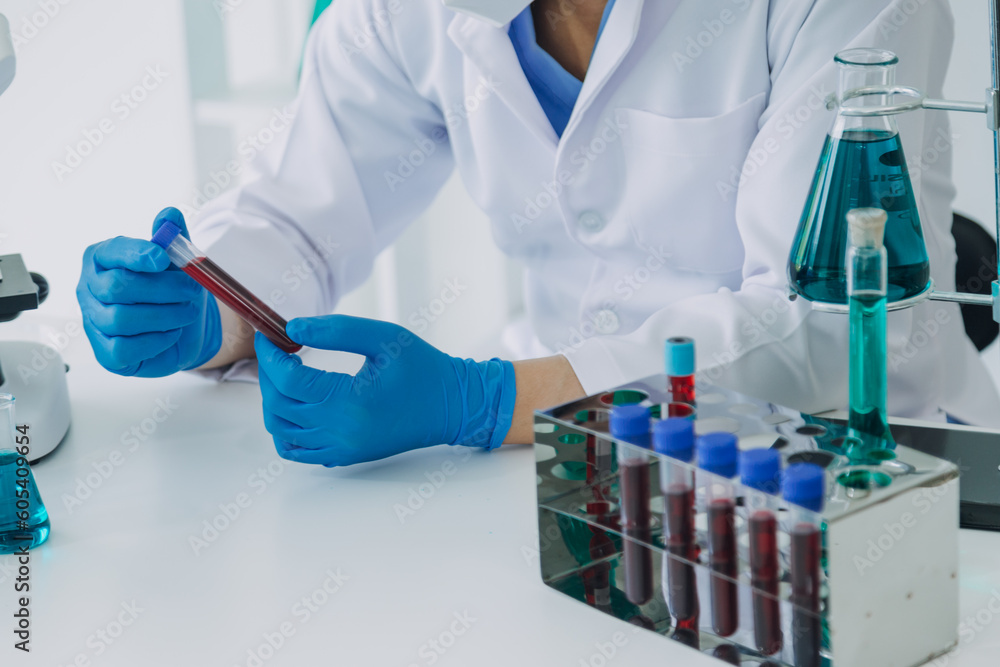 medical or scientific researcher researching and experimenting Multi-colored solution, vial and microscope In the laboratory or in the laboratory by wearing blue gloves and white clothing completely. medical or scientific researcher researching and experimenting Multi-colored solution, vial and microscope In the laboratory or in the laboratory by wearing blue gloves and white clothing completely.