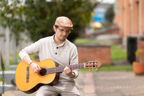 musician composing music outdoors with hat and glasses