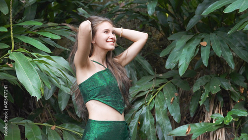 Girl in green dress in tropical leaves