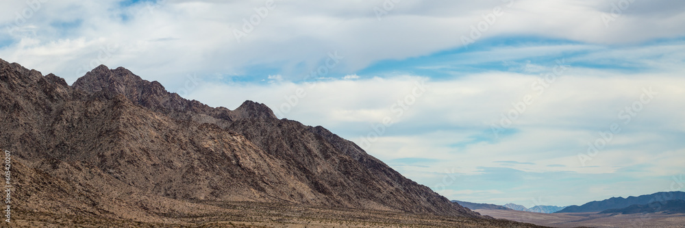 Panoramic landscape views in the Mojave desert during day time with rocks, trees, flat, boulder landscape. Tourist area, popular, camping, camp, road trip, California view.