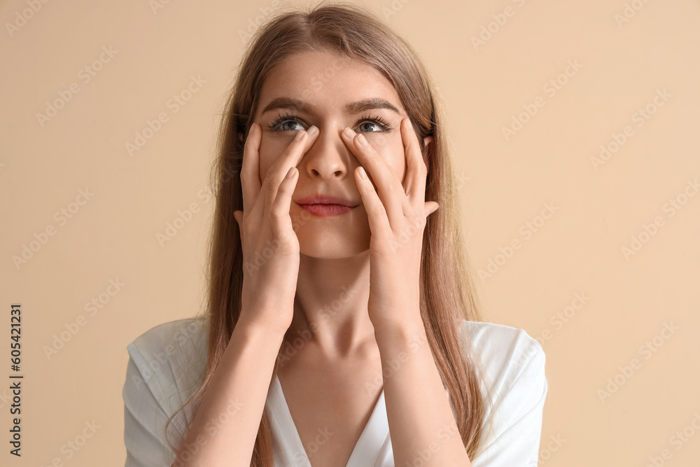 Young woman doing face building exercise on beige background, closeup Young woman doing face building exercise on beige background, closeup