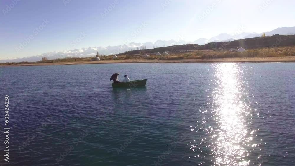 Romantic walk of two lovers on an antique boat in Issyk-Kul lake Romantic walk of two lovers on an antique boat in Issyk-Kul lake