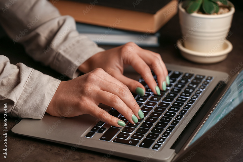 Woman working with modern laptop on brown table Woman working with modern laptop on brown table