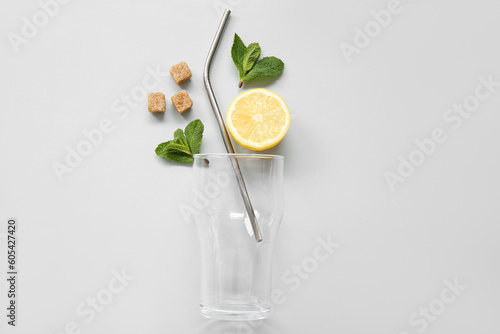 Glass with lemons and mint on grey background