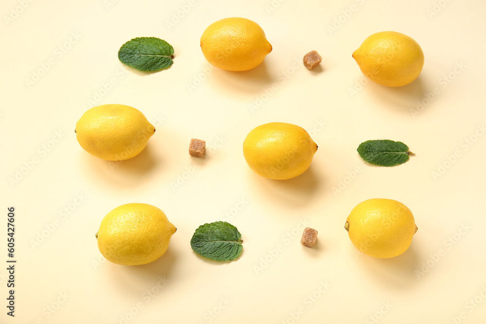 Ripe lemons with mint and brown sugar on pale yellow background Ripe lemons with mint and brown sugar on pale yellow background