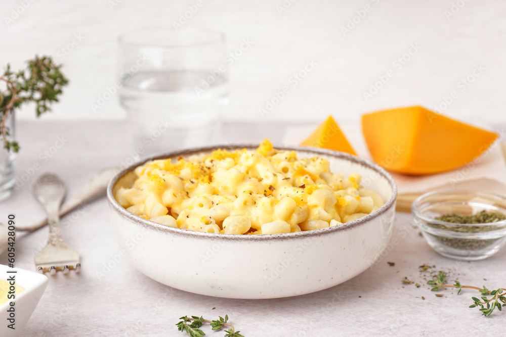 Bowl of tasty Italian pasta with Cheddar cheese on light background Bowl of tasty Italian pasta with Cheddar cheese on light background