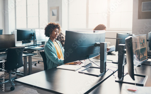 Smiling businesswoman and colleagues working on computers in a bright office