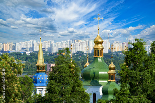City landscape with ancient Vydubitsky Monastery, river Dnieper and modern high-rise buildings in Kyiv