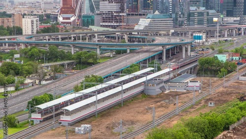 Small Ring of the Moscow Railways timelapse. Orbital railway in Moscow, Russia. Shelepikha Station aerial top view with traffic on third transport ring and skyscrapers behind photo