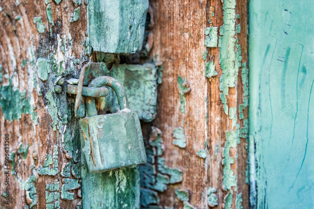 Old rusted padlock on a blue wooden door