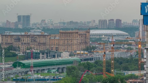 Moscow timelapse, evening aerial top view of the third transport ring and the central part of Moscow's rings, traffic, bridge over the river from rooftop. Luzhniki stadium on background before sunset