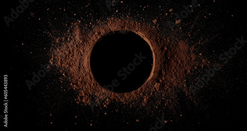 Cocoa powder pile in shape circle isolated on black, top view