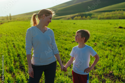 Happy mother and son in the field looking at each other on a sunny day