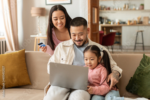 Japanese Family Shopping Using Laptop And Credit Card At Home