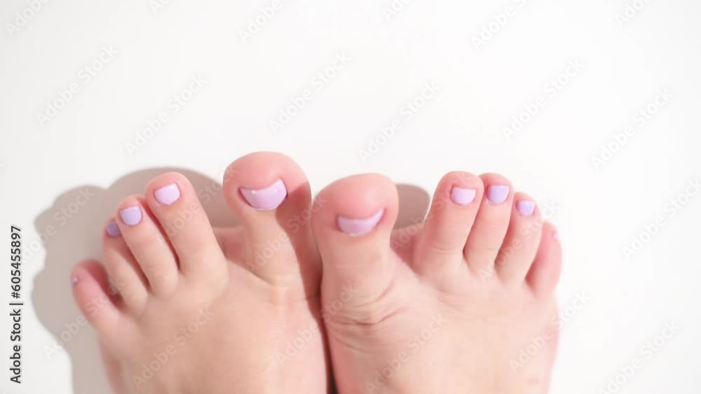 Top view pedicured feet with painted into pink nails. Legs on white background horizontal 4k footage. Beauty concept . Top view pedicured feet with painted into pink nails. Legs on white background horizontal 4k footage. Beauty concept .