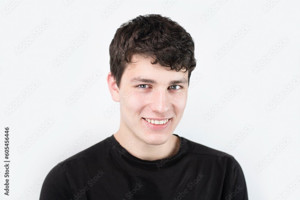 Cute manly guy with nice smile and white healthy teeth on light background, boy 18 years old smiling and happy to succeed in college Cute manly guy with nice smile and white healthy teeth on light background, boy 18 years old smiling and happy to succeed in college
