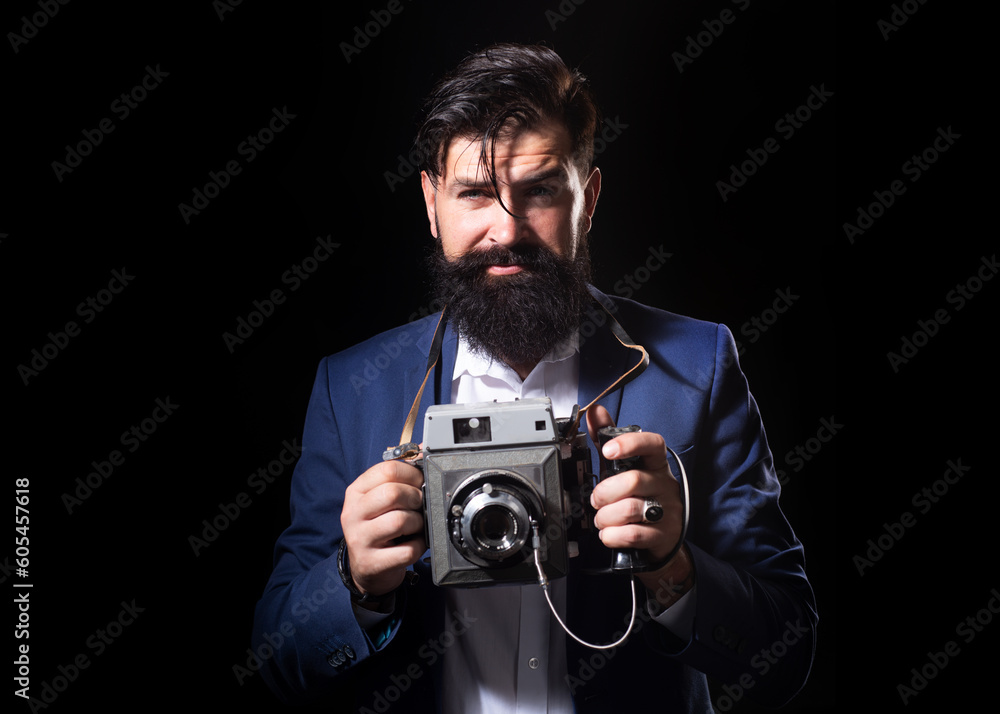 Bearded old man photographer with a large old professional camera. Portrait of man photographer with vintage retro old film camera isolated on a black background. Retro photographer. Bearded old man photographer with a large old professional camera. Portrait of man photographer with vintage retro old film camera isolated on a black background. Retro photographer.