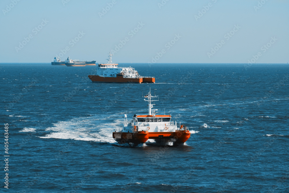 Embarkation and disembarkation of the pilots to and from the vessels. Pilotage of the ship in Europe. German marine pilots association. Catamaran pilot vessel off the coast of Germany. Embarkation and disembarkation of the pilots to and from the vessels. Pilotage of the ship in Europe. German marine pilots association. Catamaran pilot vessel off the coast of Germany.