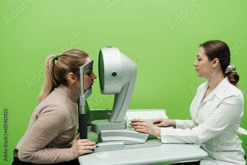 Corneal topography eye vision test for visual description of the shape and power of the cornea. Optometrist is scanning eyes of patien using kerato topograph in ophthalmology clinic. photo