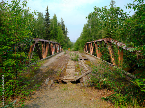 Old and rotten wooden bridge across a creek on the old Alaska Highway falling apart due to wood rot