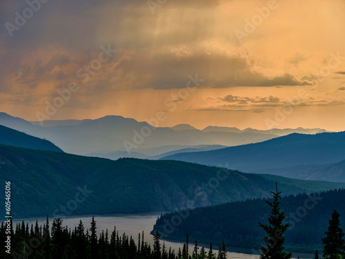 Sunset in Alaska with the mountains and a rain shower in the distance showing the emptiness of the country near the Yukon River