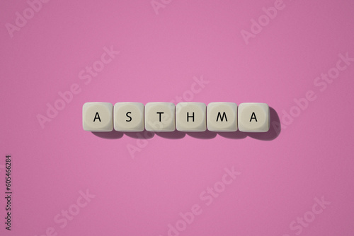 Asthma inscription. On wooden cubes. On a pink background.