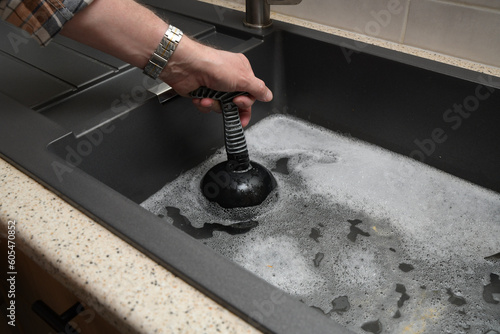 Overflowing kitchen sink, clogged drain.