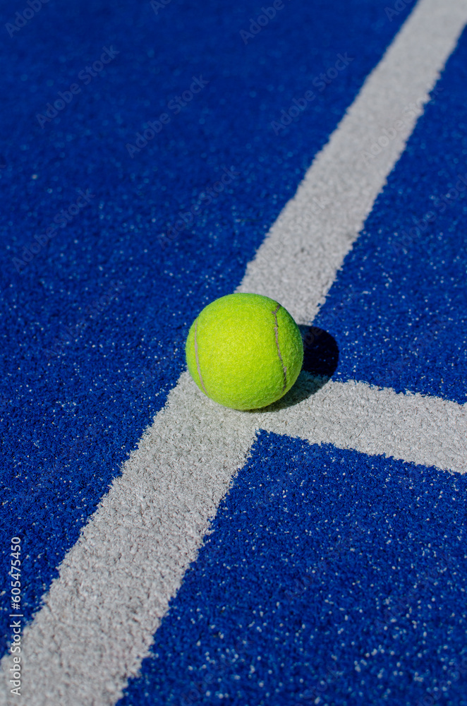 ball on the line of a blue paddle tennis court
