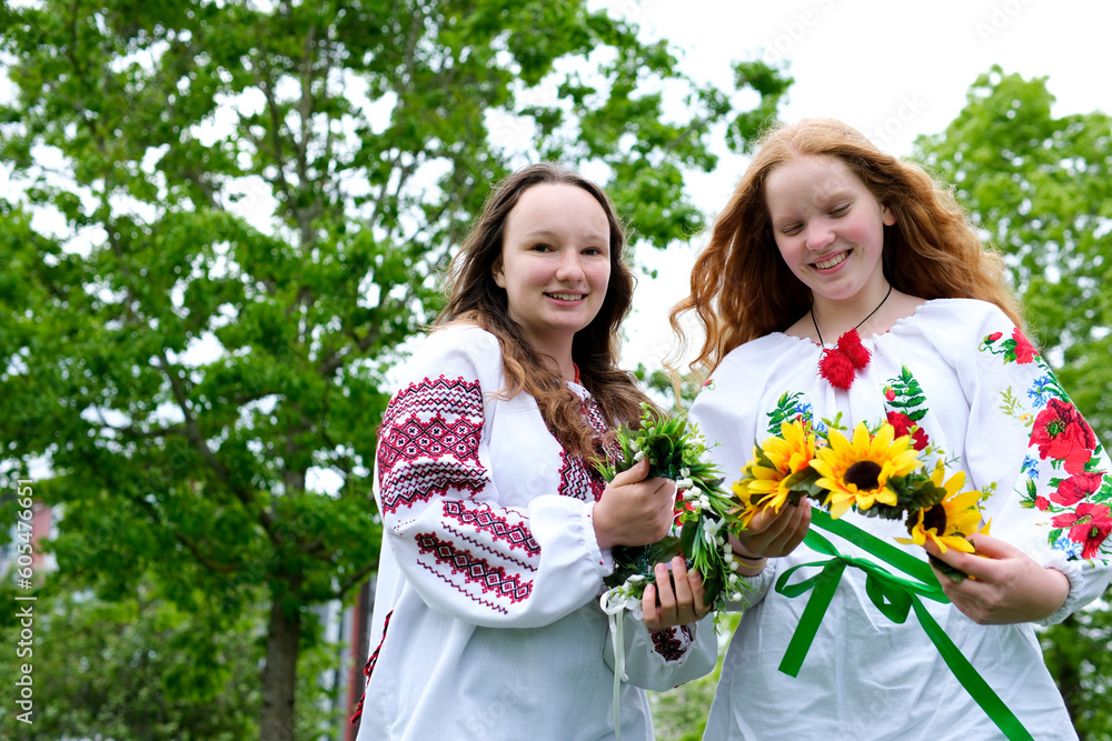 beautiful young teenage girl in wreath for Ukrainian holiday with friend communicate place for advertising text ukrainian tradition put a wreath on her head weave braids embroidered shirts