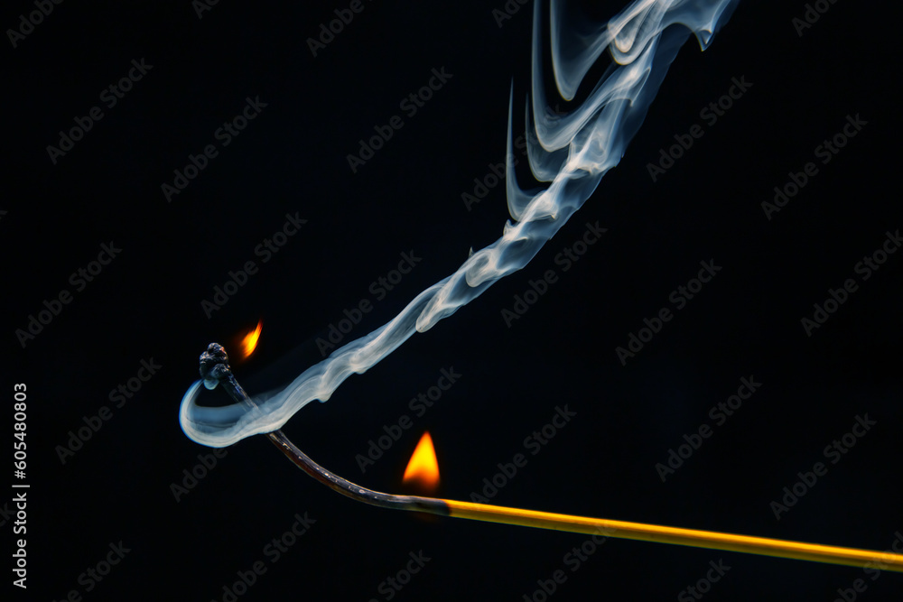 Flashed and burning wooden match on a dark background close-up. Bright fire and smoke from a burning tree. Flashed and burning wooden match on a dark background close-up. Bright fire and smoke from a burning tree.