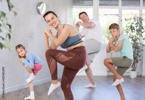 Positive pre-teenage dancers and his parent doing dance workout during group class