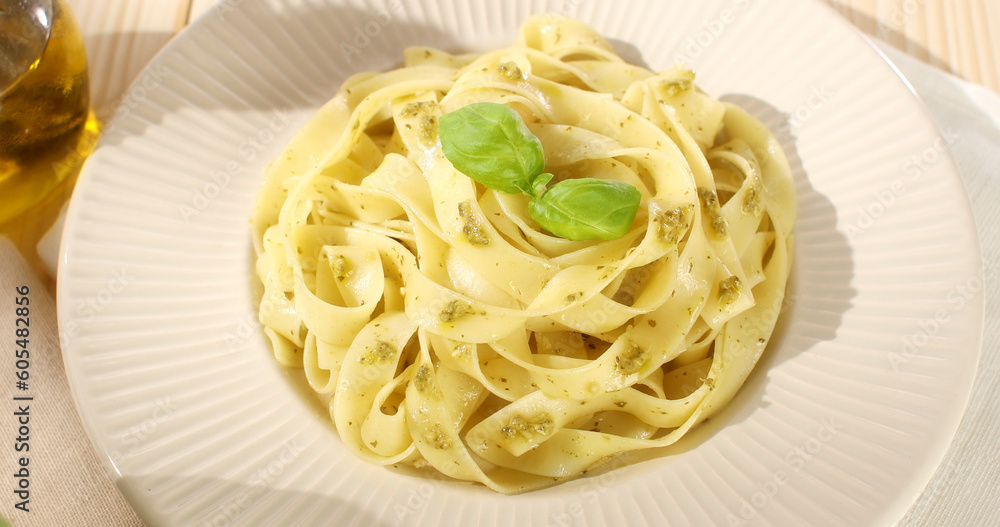 pasta with pesto on a plate. serving fettuccine with pesto. italian food with traditional sauce. recipe visualization. mediterranean cuisine. angle view. pov. pasta with pesto on a plate. serving fettuccine with pesto. italian food with traditional sauce. recipe visualization. mediterranean cuisine. angle view. pov.
