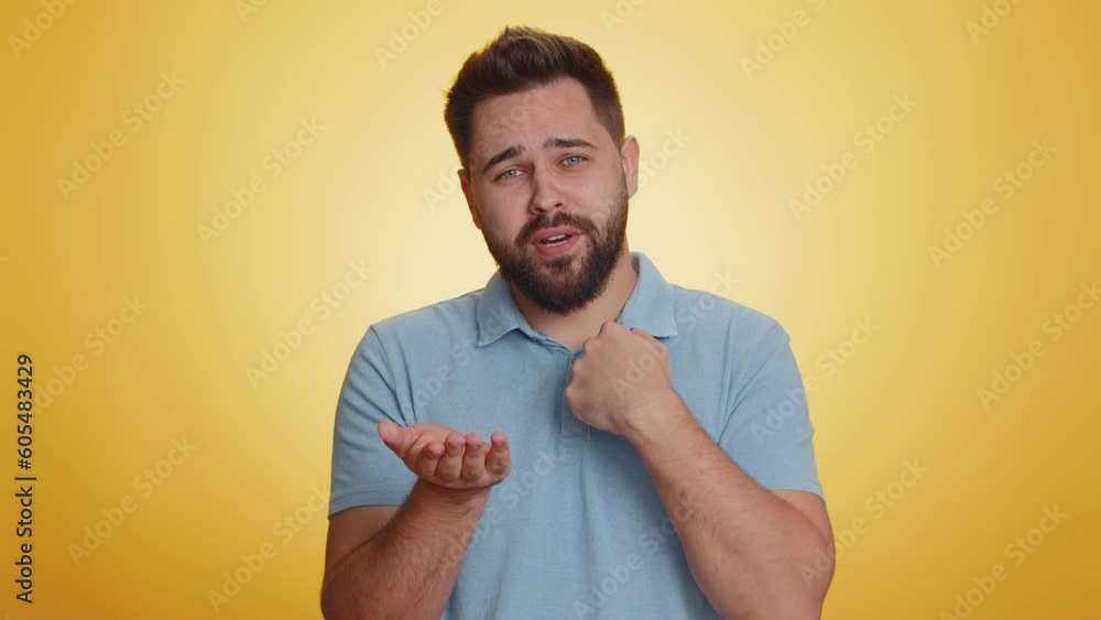 Need some more, please give me. Caucasian man showing a little bit gesture with sceptic smile, showing minimum sign, measuring small size. Handsome guy isolated alone on yellow studio background