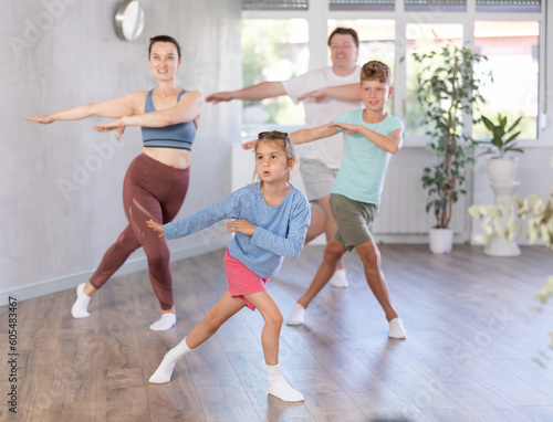 Family with two children engaged in active dancing in fitness studio