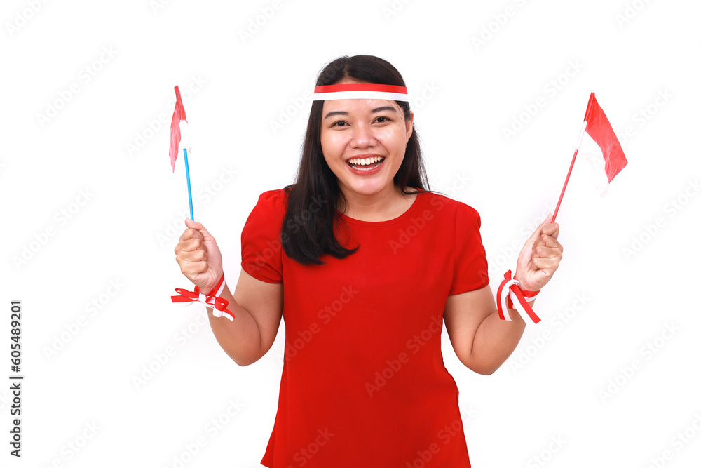 Fototapeta premium Cheerful young indonesian girl standing while holding red white flag. Isolated on white