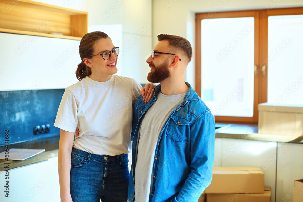 Obraz premium Hugging couple celebrating moving Into new home