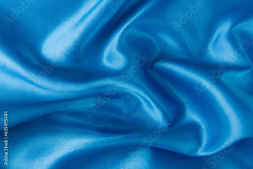 Abstract blue silk fabric texture background. Creases of satin 
